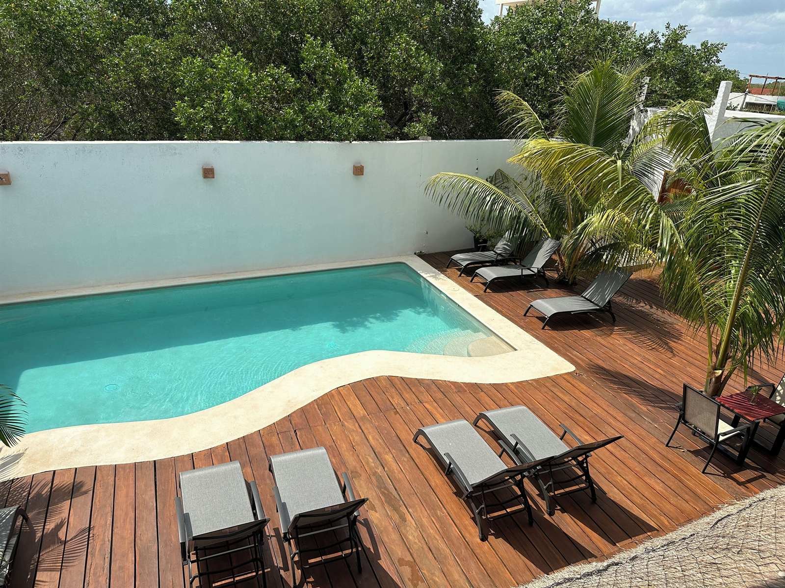 La Casa del Sol Holbox: pool with a wooden deck, loungers and palm trees